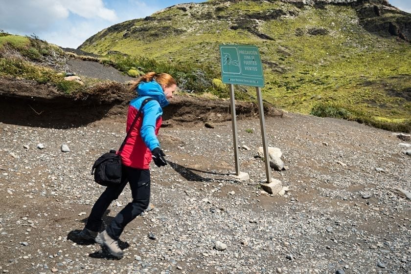 A person posing in a strong wind in Torres del Paine national park in Patagonia.