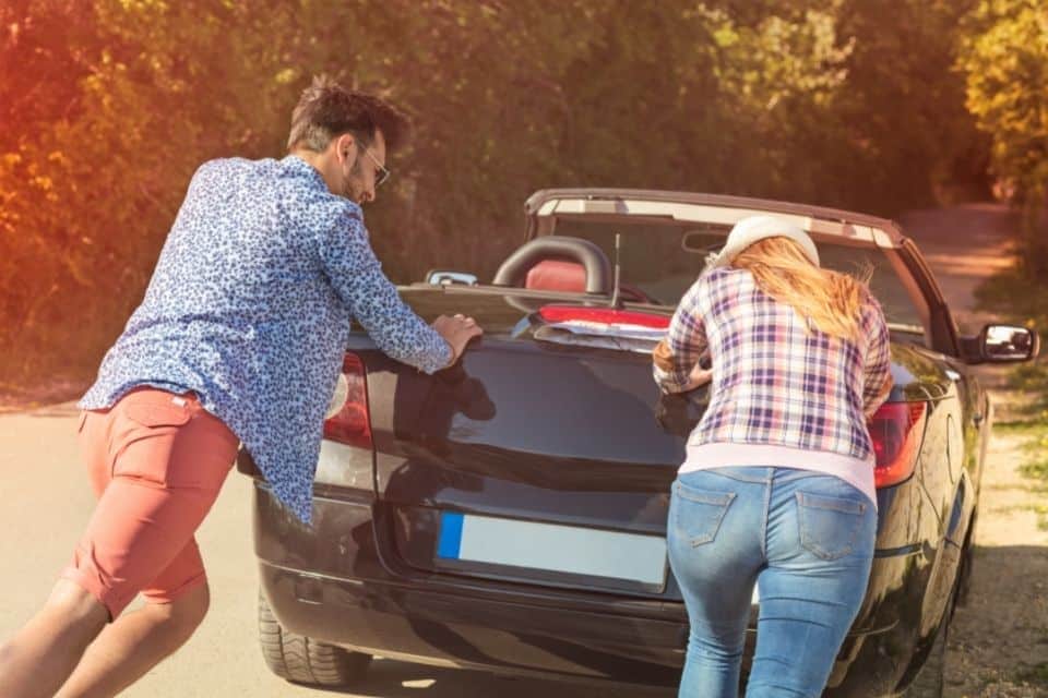 two people pushing a car