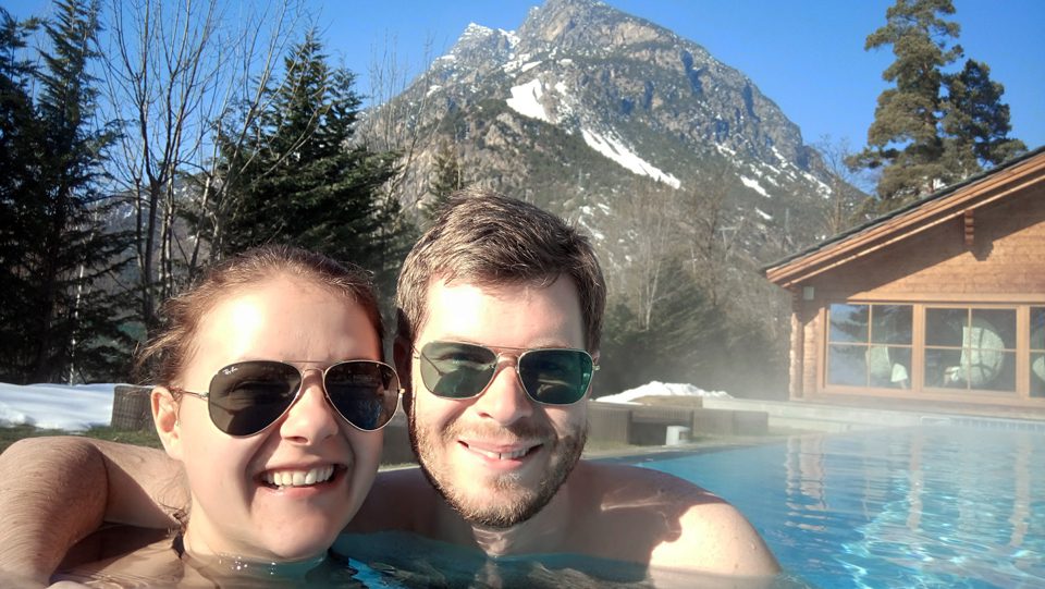 outside in a pool in a spa in Bormio with a mountain in the background