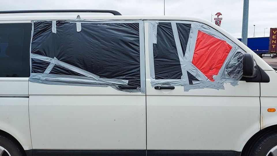 car with windows fixed by tape and foil