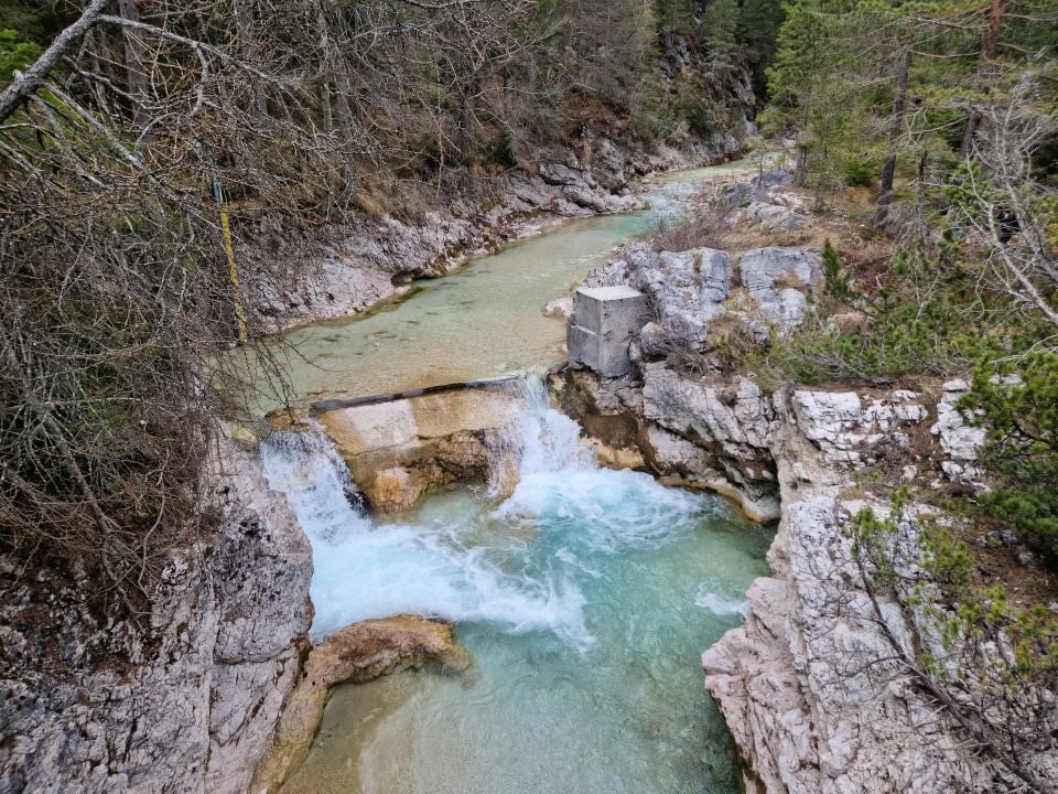 a waterfall on the river boite with dolomite rocks all around them - dolomites, italy