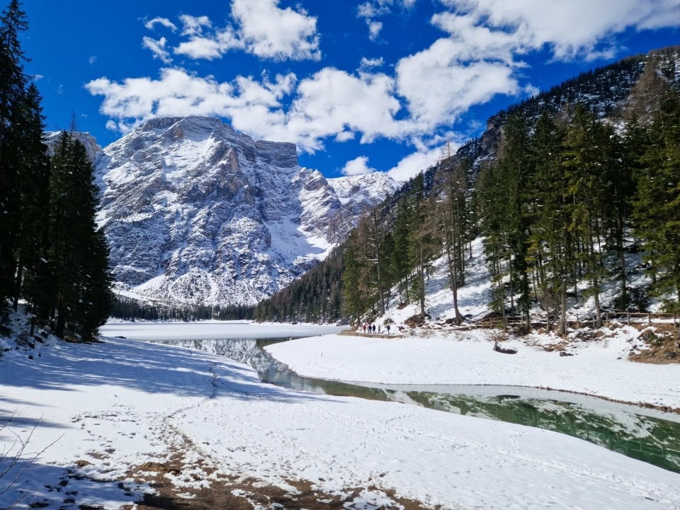 river braies and lake braies as seen from the bridge side with lots of snow and turquoise waters; dolomites in april italy