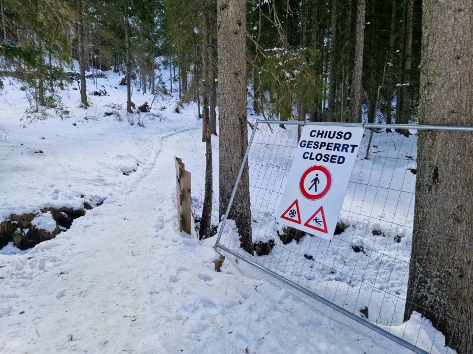 a sign of closed path because of danger of slipping lago braies dolomites italy