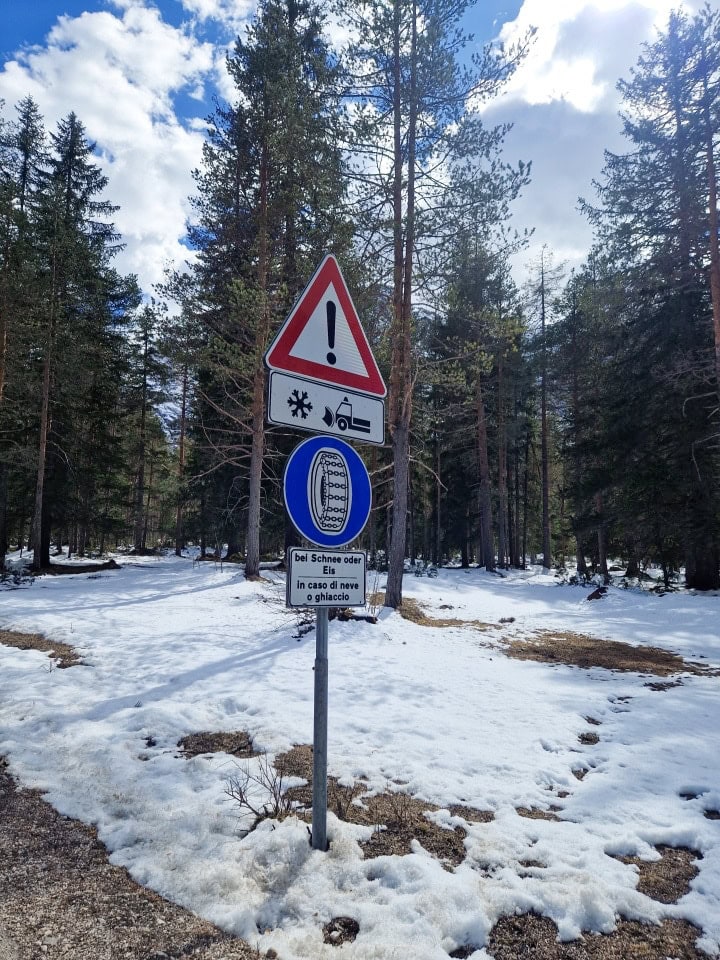 a sign that says that in case of snow, cars have to have chains on their tyres in dolomites italy