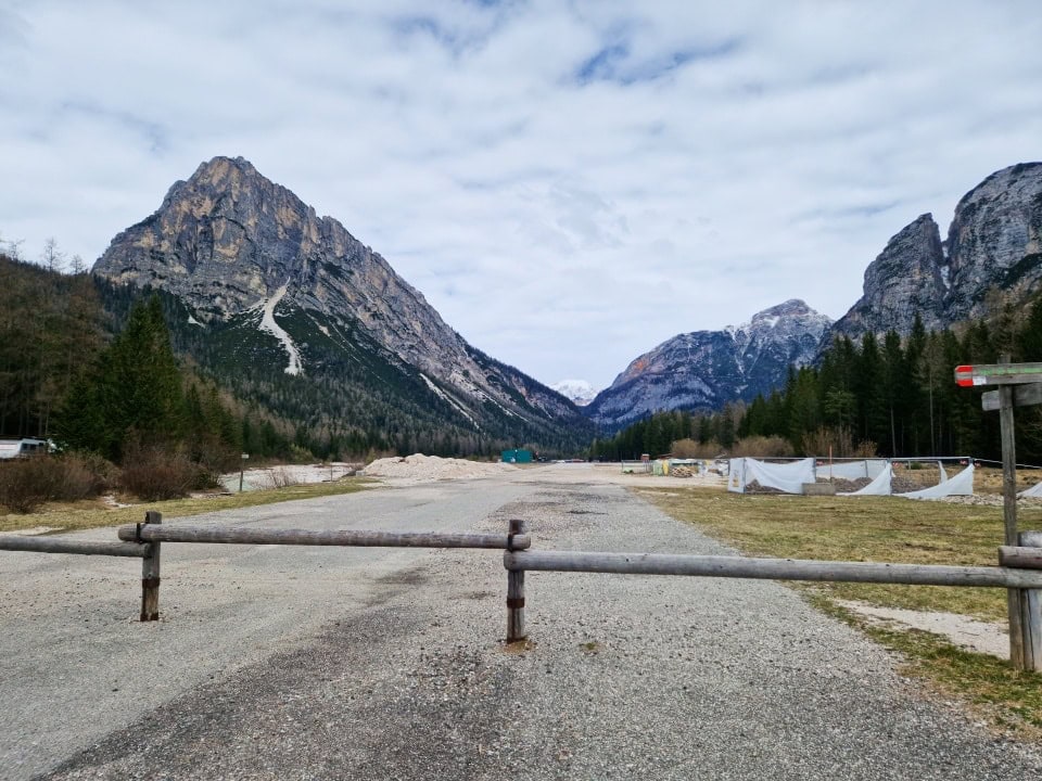 a small airstrip of the cortina d'ampezzo airport with snowy and not snowy mountains in the background in dolomites italy