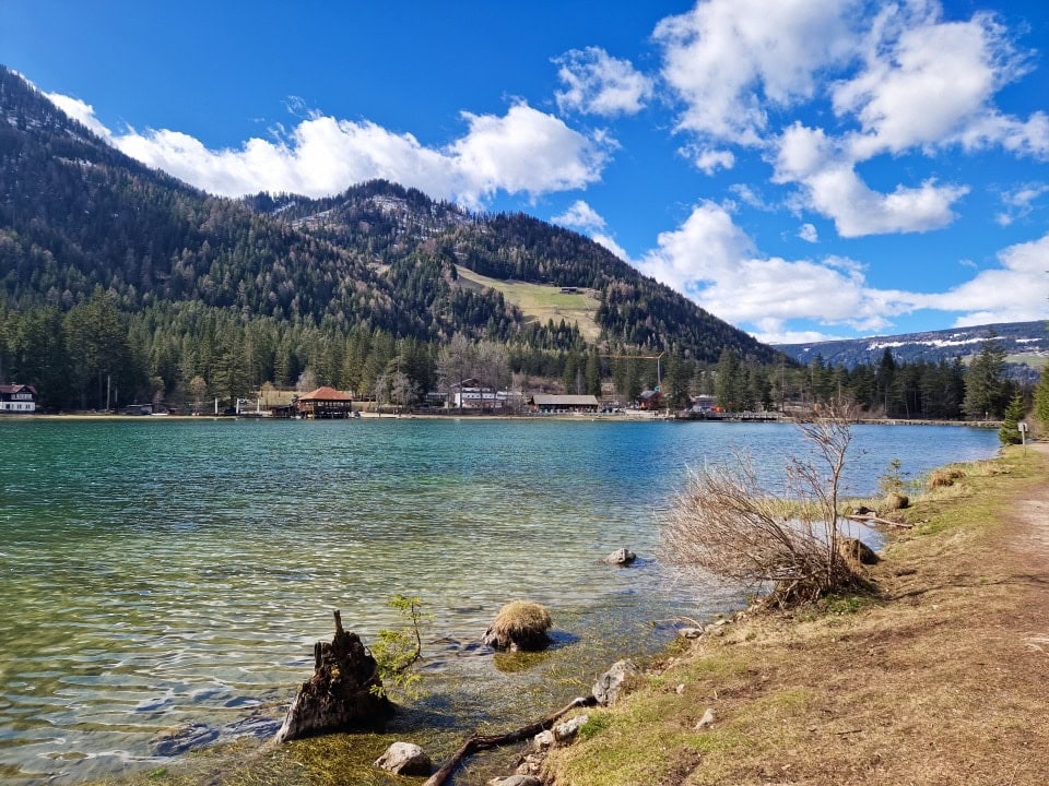 a view of a camping and hotel with lake dobbiaco in the foreground in dolomites italy