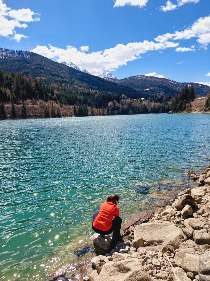 me washing hands in the turquoise green lake valdaora in dolomites italy - the water was very cold