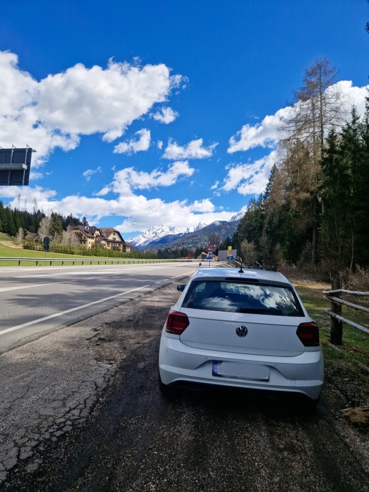 a white car parked on the side of the road in dolomites italy