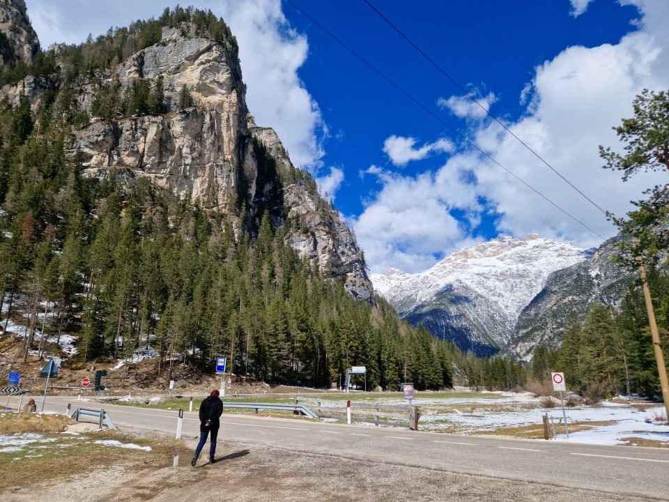 a parking lot with lots of snowy mountains around it in dolomites italy