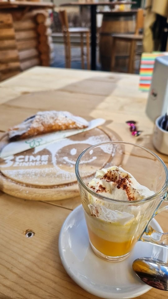 a cannolo and a bombardino in a cafe in dobbiaco, dolomites, italy